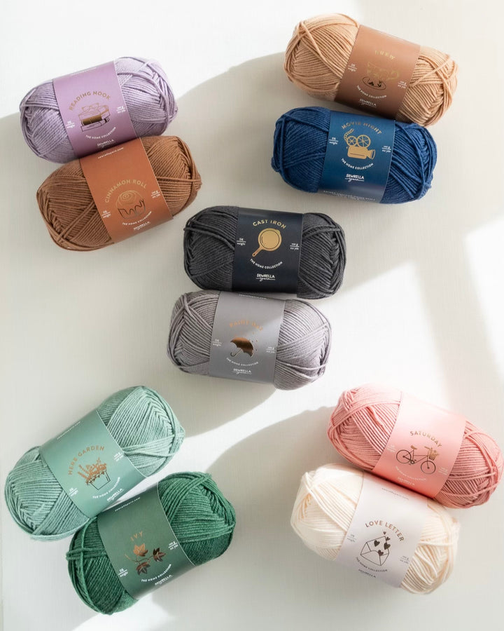 Assorted colorful yarn balls on a white surface
