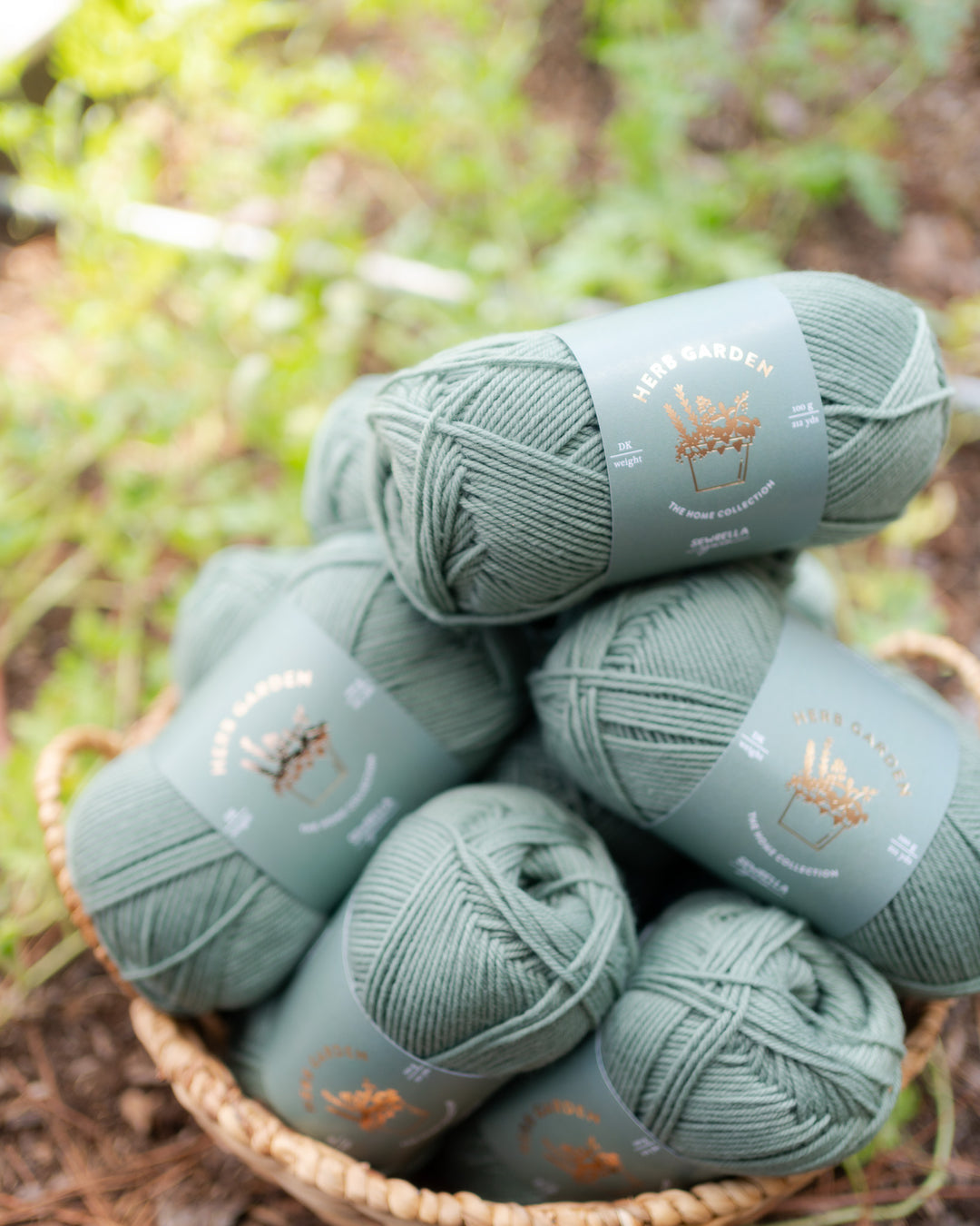muted soft green dk wool yarn in a basket